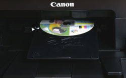 Canon: Den bedruckbaren Datenträger muss man mit dem mitgeliefertem Halter in den Drucker einführen.