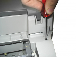 Schraube lösen: Als erstes entfernt man die Abdeckung an der Rückseite des Druckers.