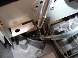 Mit einem Schraubendreher kann man den Schlauch nach dem Aufsetzen des Druckwerks wieder in seine Halterung drücken.
