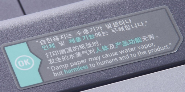 Samsung CLP-660ND: Winziger Aufkleber warnt vor aufsteigendem Dampf aus dem Drucker.