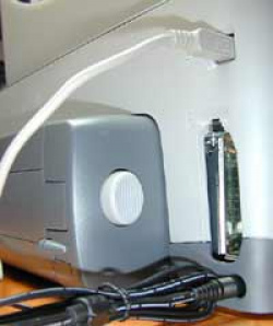 Serienmäßig: Eine Duplexeinheit, die das Papier im Drucker wendet. Im Bild sind auch die USB-Schnittstelle und der LIO-Schacht für Parallel oder Netzwerk zu sehen.