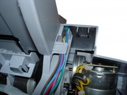 Vor dem Anheben des Druckwerks muss das Kabel vom Netzteil aus der Führung am Druckwerk gezogen werden.
