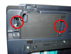 Um das Netzteil anschließend zu entfernen, biegt man die beiden Clips an der Unterseite des Druckers vom Netzteil weg.