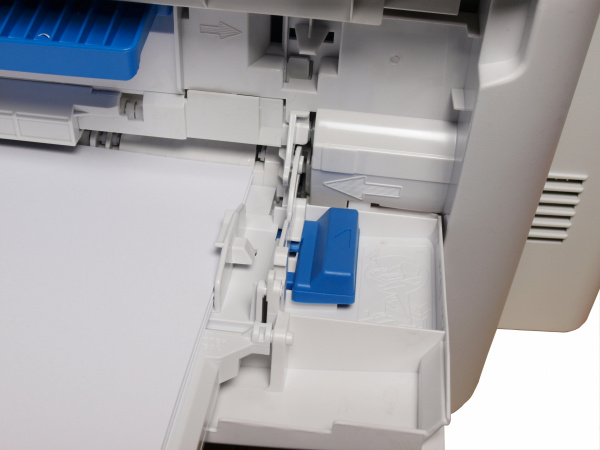 Papierheber: Damit der Papiereinzug im Bypass funktioniert, muss der Anwender die Druckmedien mit dem blauen Knopf manuell anheben.