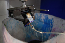 Tintenpatrone reinigen: Nachdem die restliche Tinte in einer Zentrifuge entfernt wurde, wird die Patrone mit Hilfe von Druckluft und einem Lösungsmittel gereinigt.