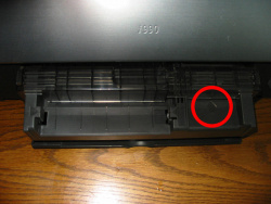 Nach dem Einsetzen der CD-Schlitten-Führung muß das durchsichtige Plastikoberteil nach vorn geschoben werden, bis der rot umrandete Pfeil zu sehen ist.