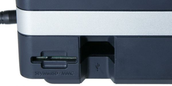 HP Officejet 470: Links an der Seite hat der HP einen Speicherkartenleser (SD und MMC) und den USB-Hostanschluss angebracht. Dort findet zum Beispiel der Bluetooth-Adapter Platz.