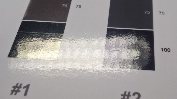 Pigmentschwarz vs. Dyeschwarz: Beim Druck auf Glanzpapier ist der Unterschied besonders deutlich. Pigmenttinte (links) zieht nicht komplett ins Papier, bleibt näher an der Oberfläche und zeigt dann metallische Reflexionseigenschaften ("Bronzing") als Dyetinte (rechts).