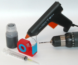 Das brauchen Sie: Tinte, Bohrer, Spritze, Klebeband, Heißklebepistole.