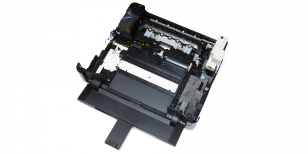 Bodeneinheit des Druckers: Zahlreiche Schwämme verteilen sich auf den Gehäuseboden und eine Plastikbox rechts hinten.