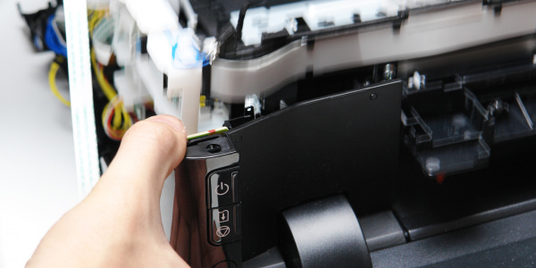Druckwerk einsetzen: Ziehen Sie das Tastenpanel etwas nach vorne, damit sich das Druckwerk mit seinen Kabeln nicht daran verhakt.