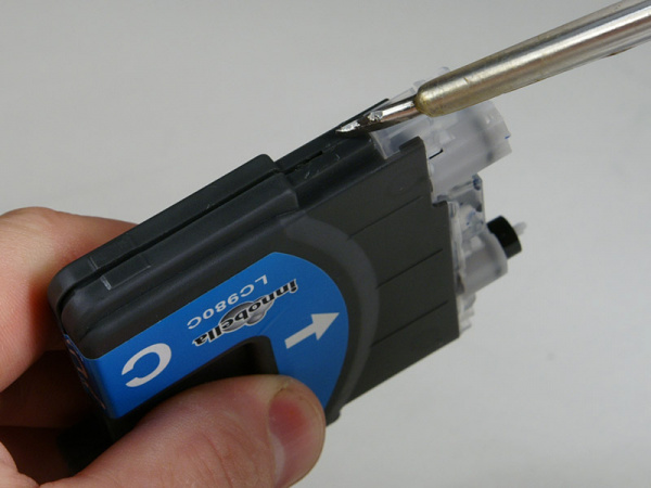 Aufhebeln 1: Setzen Sie einen flachen Schraubendreher an der gezeigten Stelle an.