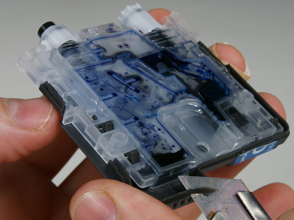 Platz schaffen: Mit einem Teppichmesser schneiden Sie ein kleines Stück vom Seitenrand weg, damit Sie Bohrer, Spritze und Heißklebepistole besser ansetzen können.